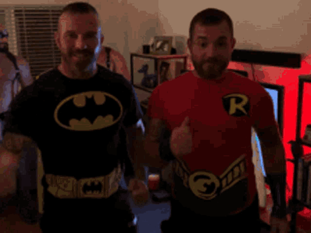 two men dressed as batman and robin are standing next to each other