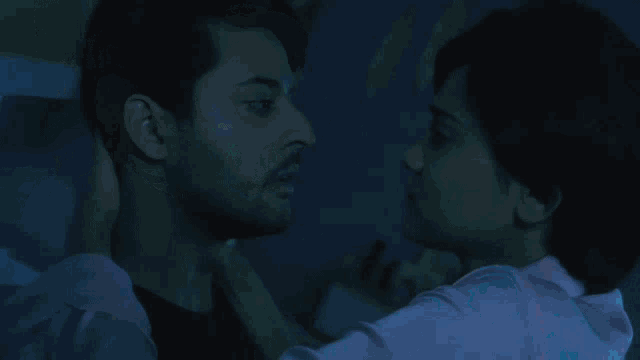 a man and a woman hugging in a dark room