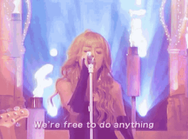 a woman singing into a microphone with the words " we 're free to do anything " written below her