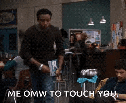 a man is standing in a room holding a book and saying `` me omw to touch you . ''