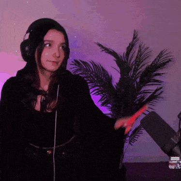 a woman wearing headphones is standing in front of a palm tree