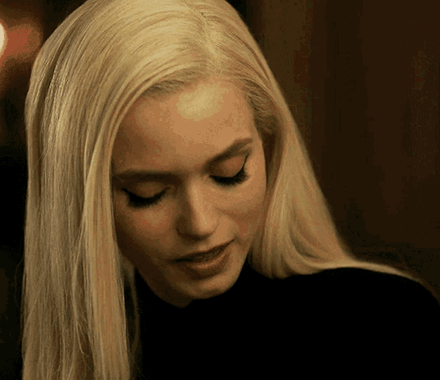 a close up of a blonde woman 's face with her eyes closed
