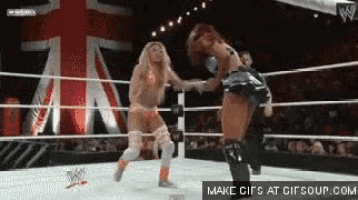 two women are wrestling in a ring with a british flag in the background ..