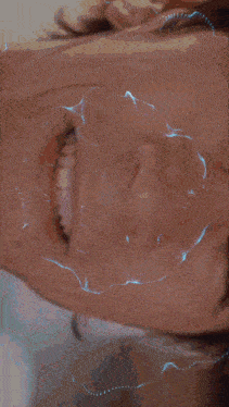 a close up of a person 's face with a grid of blue letters on it
