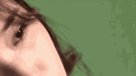 a close up of a person 's face on a green background .