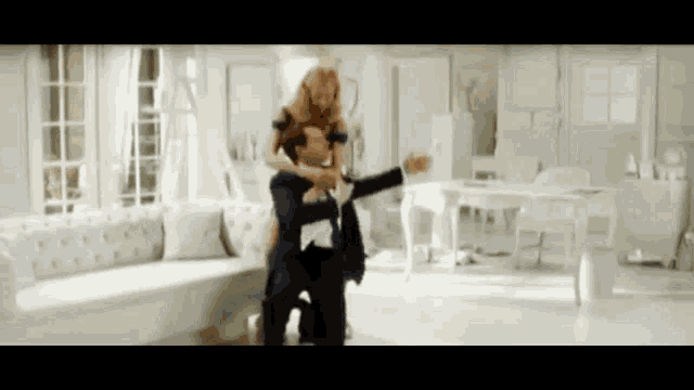 a man and woman are dancing in a living room .