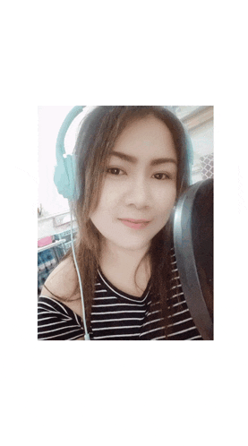 a woman wearing headphones and a striped shirt is smiling for the camera