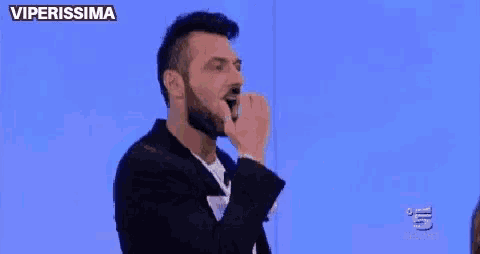 a man with a beard is talking to a woman on a tv show .