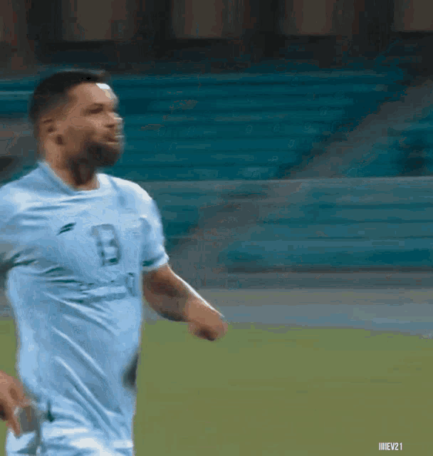 a soccer player wearing a light blue shirt with the letter b on it