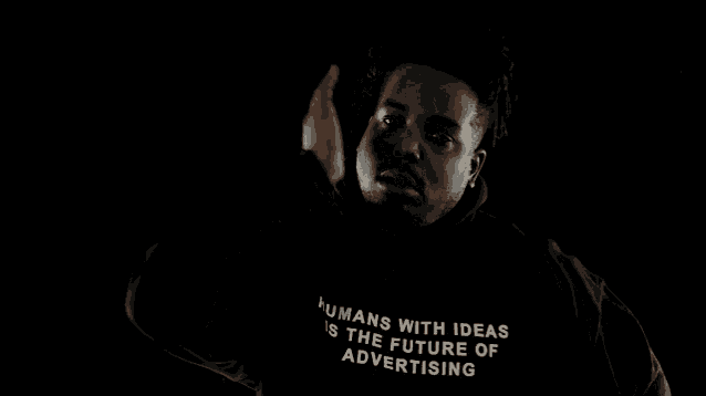 a man is wearing a black hoodie that says humans with ideas is the future of advertising