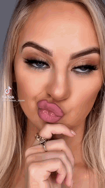 a woman with a ring on her finger making a funny face