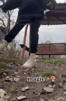 a person is standing on a dirt path in front of a park bench .