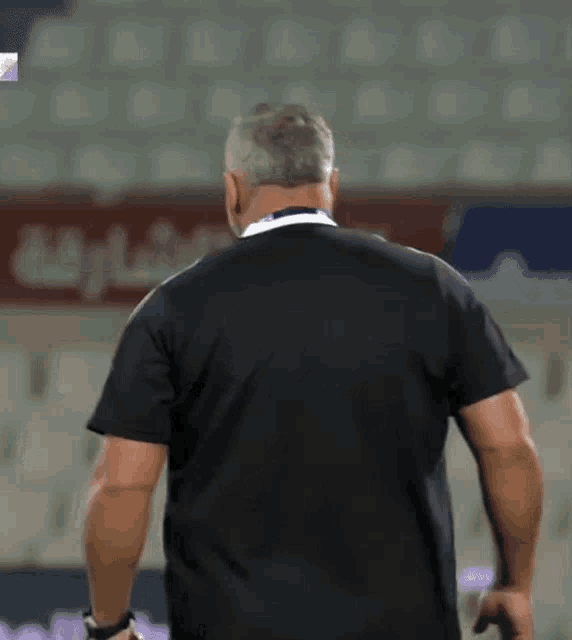 a man in a black shirt stands in front of a sign that says ' dubai '
