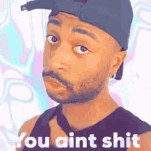 a man with a beard wearing a hat and tie says you ain t shit