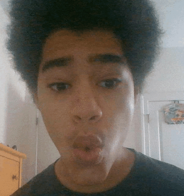 a young man with an afro is making a funny face