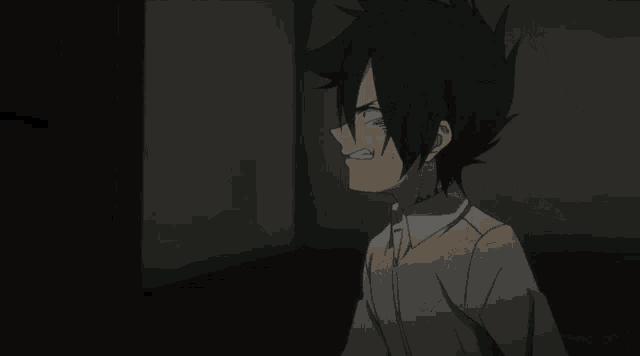 a person holding their head in a dark room with their eyes closed