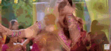 a woman in a colorful dress is dancing in front of a crowd of people .