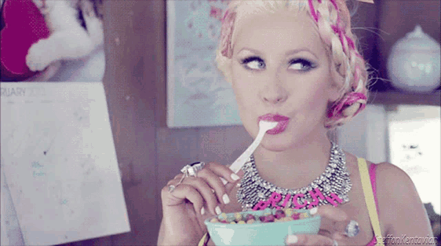 a woman eating a bowl of cereal with a calendar behind her that says february 2013