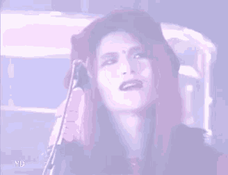 a woman with long red hair is sitting in front of a microphone .