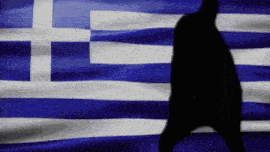a silhouette of a person is walking in front of a greek flag