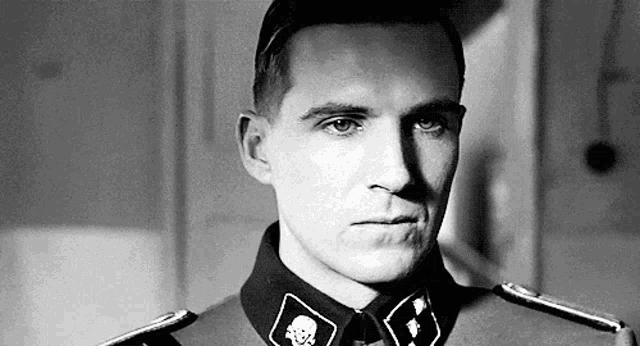 a black and white photo of a man in a military uniform with a skull and crossbones on his collar .