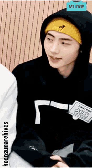 a man wearing a black hoodie and a yellow beanie
