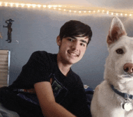 a young man and a white dog pose for a picture