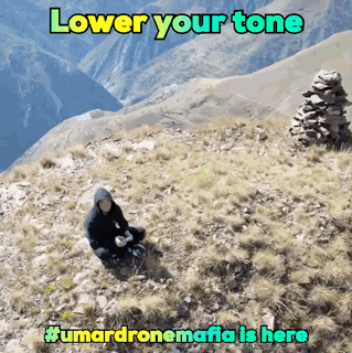 a man sitting on top of a hill with the words " lower your tone " written above him