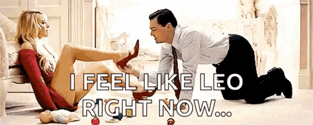 a man is kneeling down next to a woman 's leg and putting on her shoes .