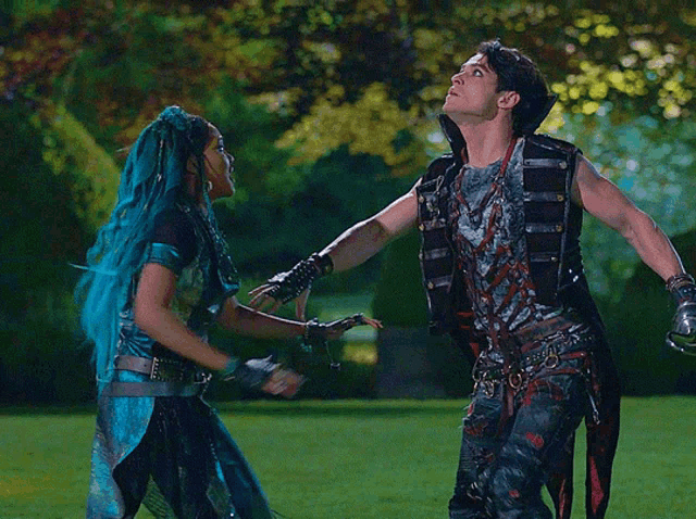a man and a woman are standing in a field holding hands