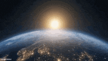 a view of the earth from space with the sun rising over it