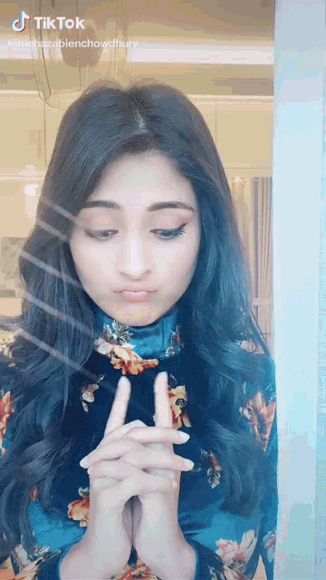 a tiktok video of a woman making a funny face with her hands folded