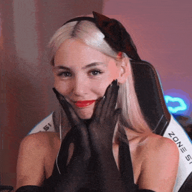 a woman wearing a headband and black gloves is sitting in a zone 51 chair