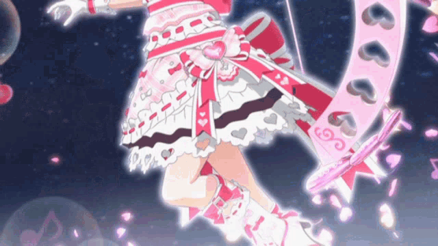a girl in a pink and white dress is holding a pink ribbon with hearts on it