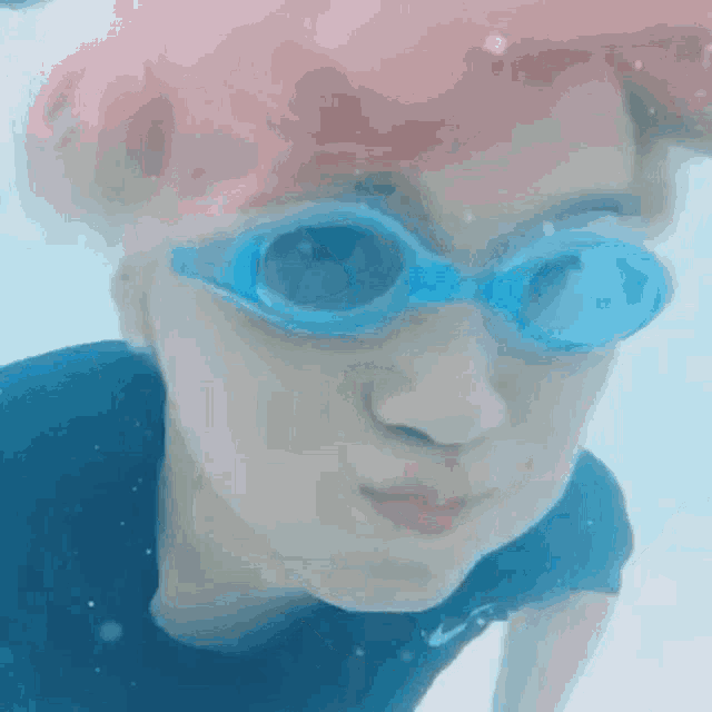 a close up of a person wearing goggles underwater .