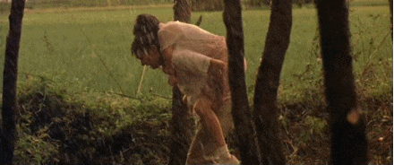 a couple of men are standing in the rain in a field .