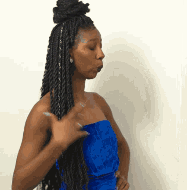 a woman in a blue dress with braids on her hair