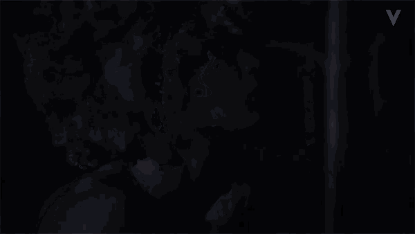 a woman 's face is shown in the dark with the letter v above her