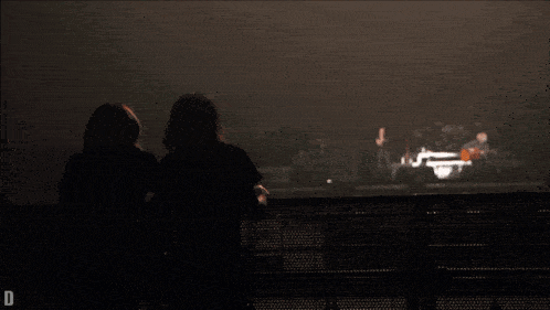 two people watching a concert with the letter d on the bottom