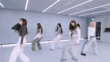 a group of girls are dancing in a room with a sign that says exit