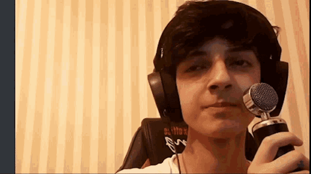 a boy wearing headphones and holding a microphone