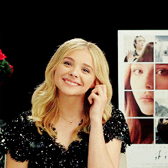 a woman is smiling in front of a poster for if