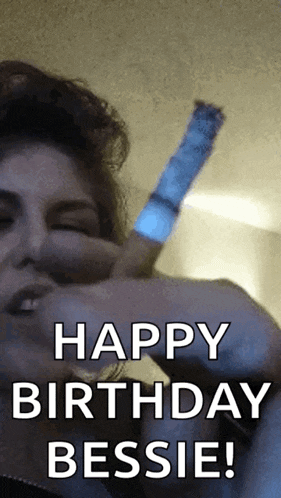 a woman is holding a light stick and says happy birthday bessie .