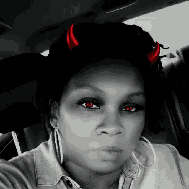 a woman with devil horns on her head is taking a selfie