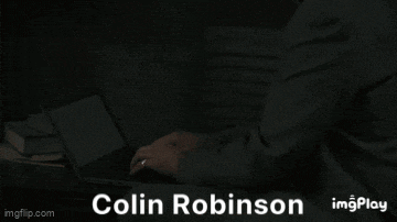 a man in a striped shirt is sitting in a dark room with the word shut behind him