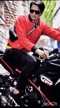 a man in a red supreme jacket rides a black motorcycle