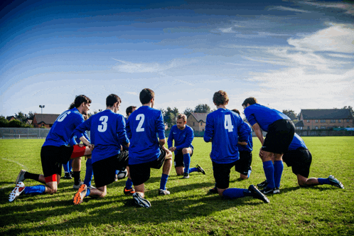 a group of soccer players wearing blue uniforms with numbers 3 2 and 4