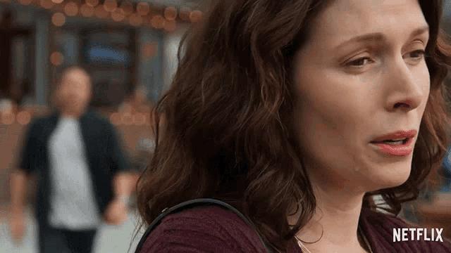 a woman is crying in front of a man and the word netflix is on the bottom of the image