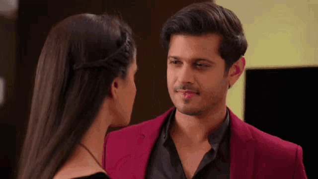 a man in a red jacket is looking at a woman