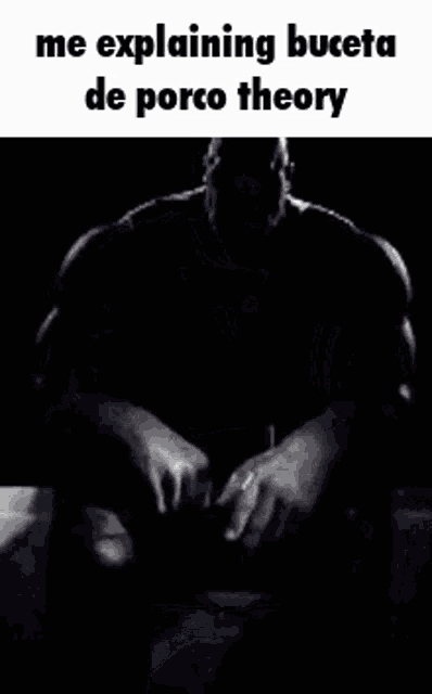 a black and white photo of a man with a beard sitting down with his hands folded .